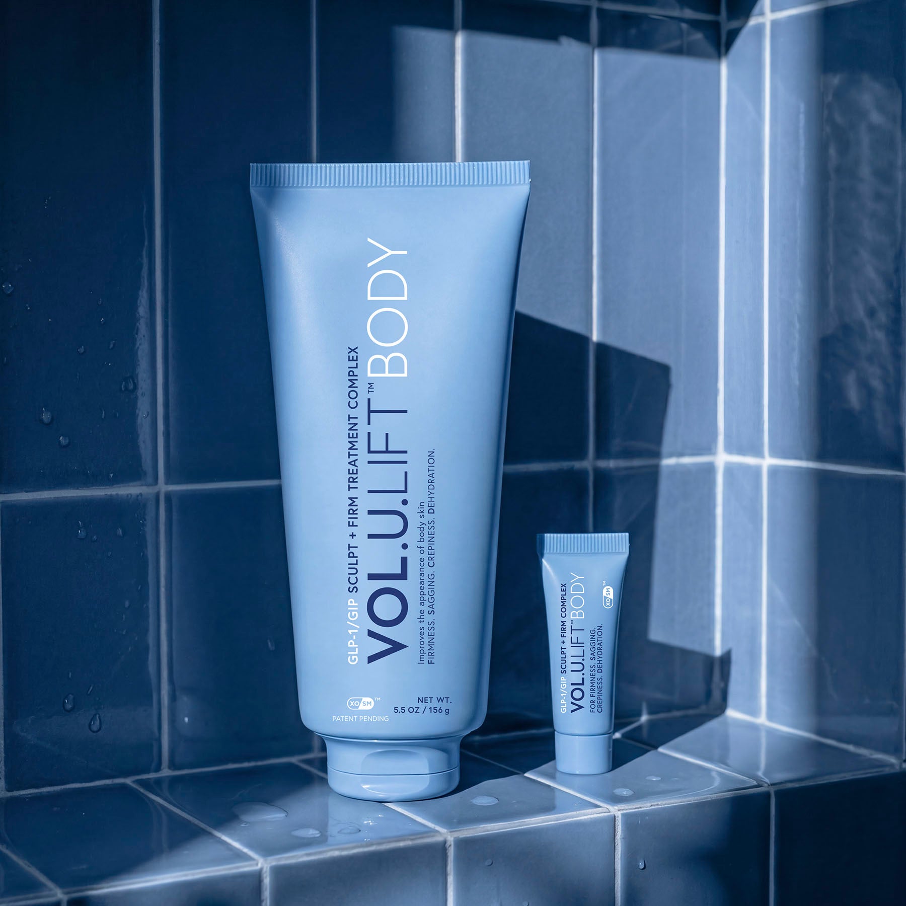 Two VoluLift Body products on a tiled bathroom floor.