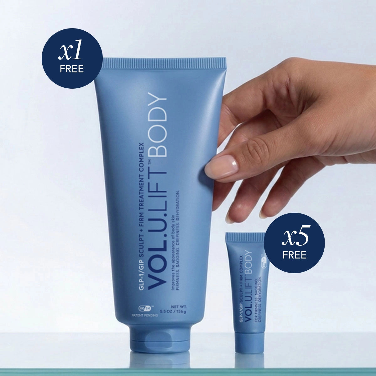 Hand holding a blue skincare tube with promotional text on a light gray background
